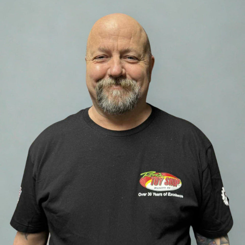 Man wearing a black t-shirt with a logo on a gray background