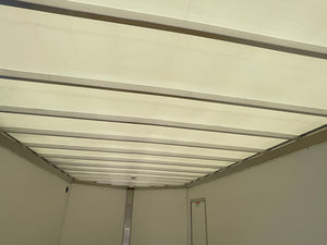 The interior ceiling and side walls of a white refrigerated truck or storage unit with metal support beams.