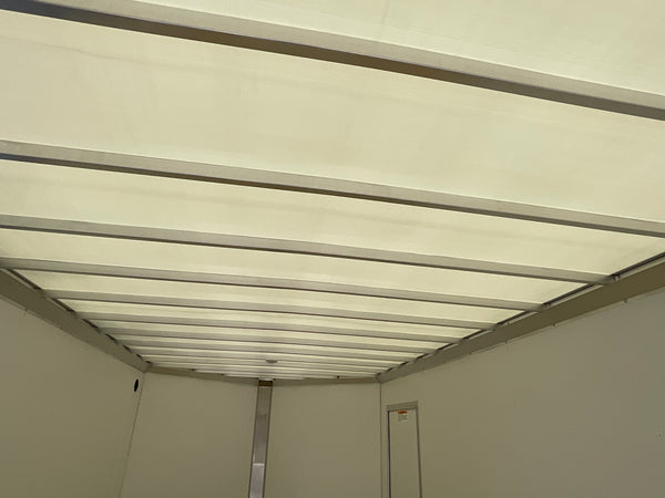 The interior ceiling and side walls of a white refrigerated truck or storage unit with metal support beams.