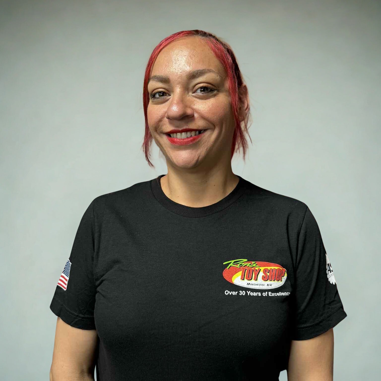 Person wearing a black t-shirt with a logo and text on a gray background
